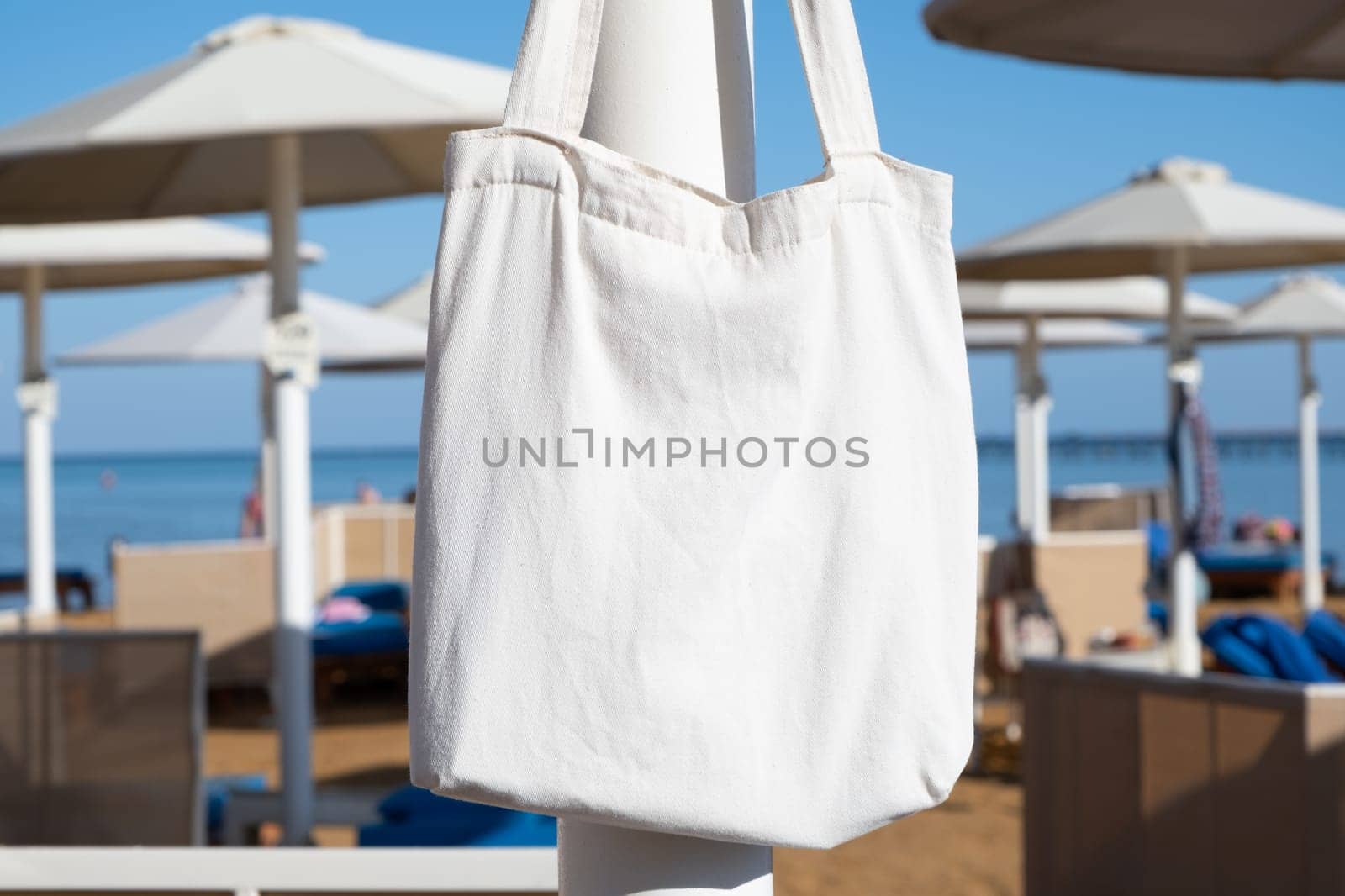 Mockup shopper handbag hanging on the beach. shopping eco reusable bag.