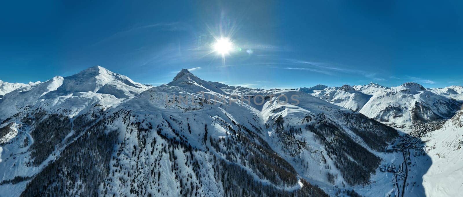 Winter drone shot of ski pistes and slopes covered with fresh powder snow in Tignes in Valdisere France. Alps aerial panoramic view on a beautiful sunny day ski lift snowboarding and skiing in resort