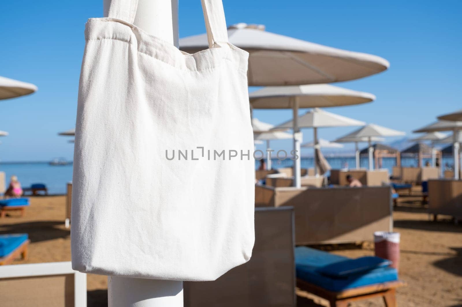 Mockup shopper handbag hanging on the beach. shopping eco reusable bag.