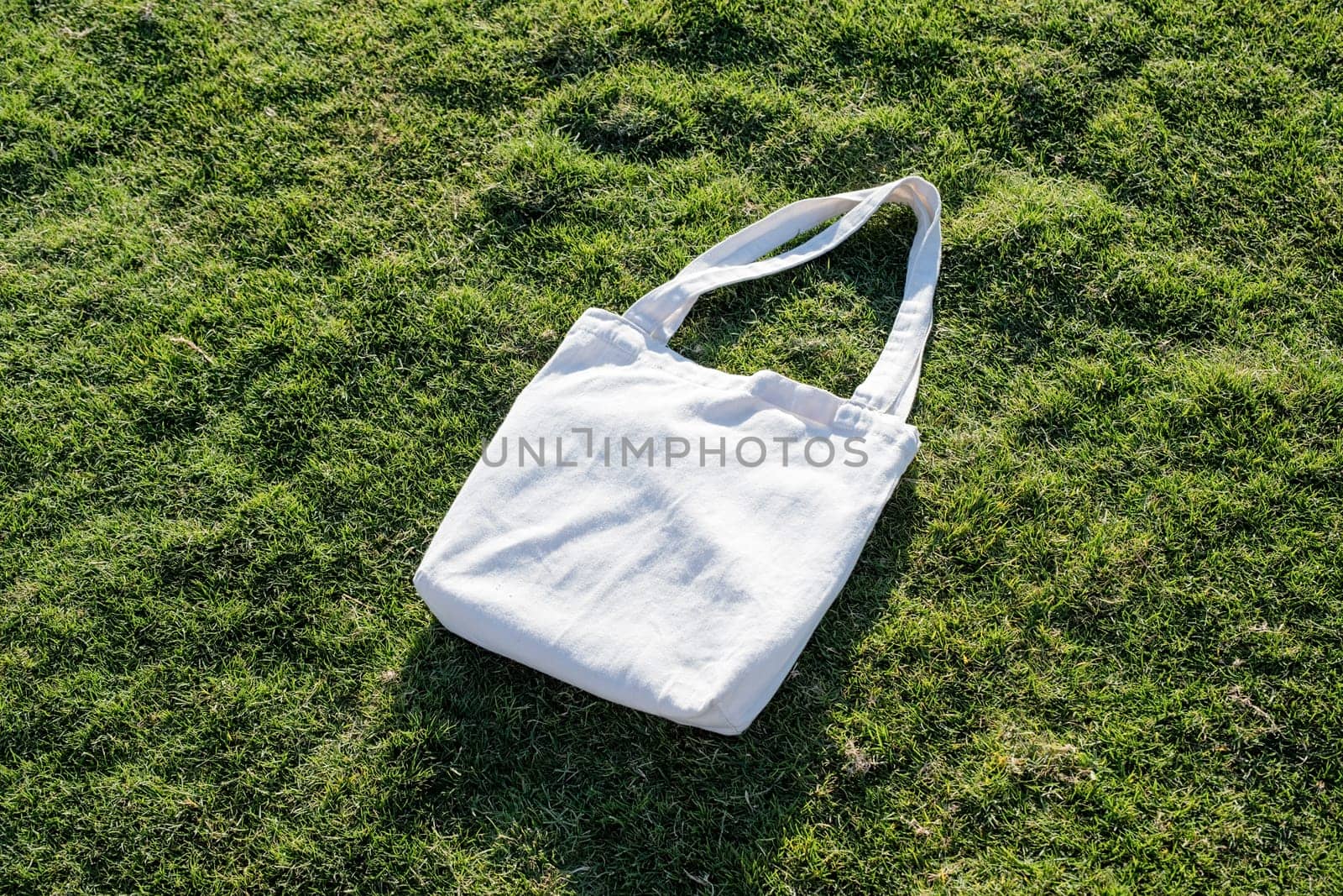 Mockup shopper handbag on green grass background by Desperada