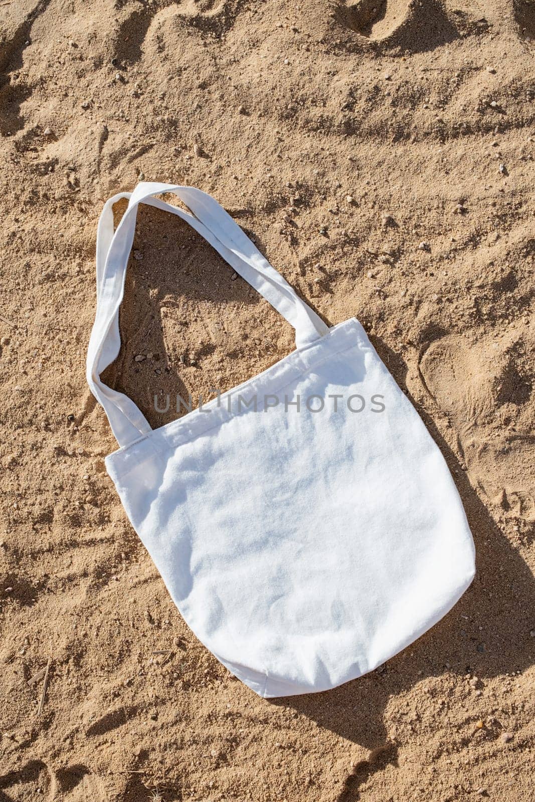 Mockup shopper handbag, beach sand background. Top view copy space shopping eco reusable bag.