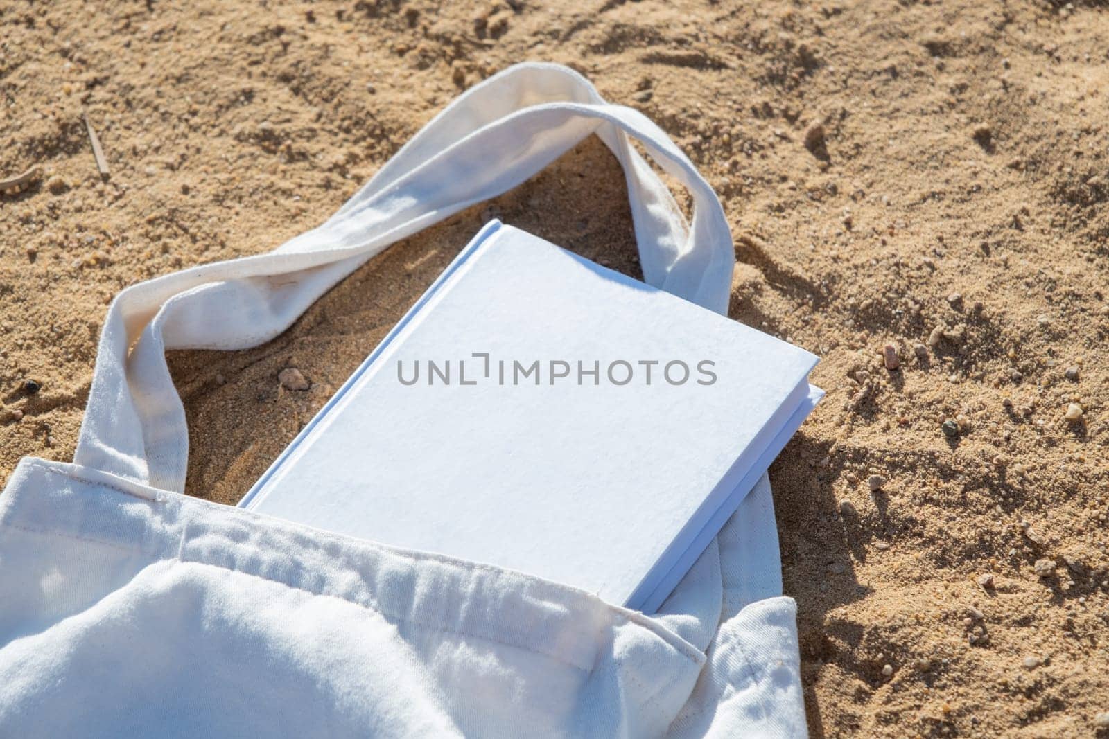 Mockup shopper handbag and book, beach sand background by Desperada
