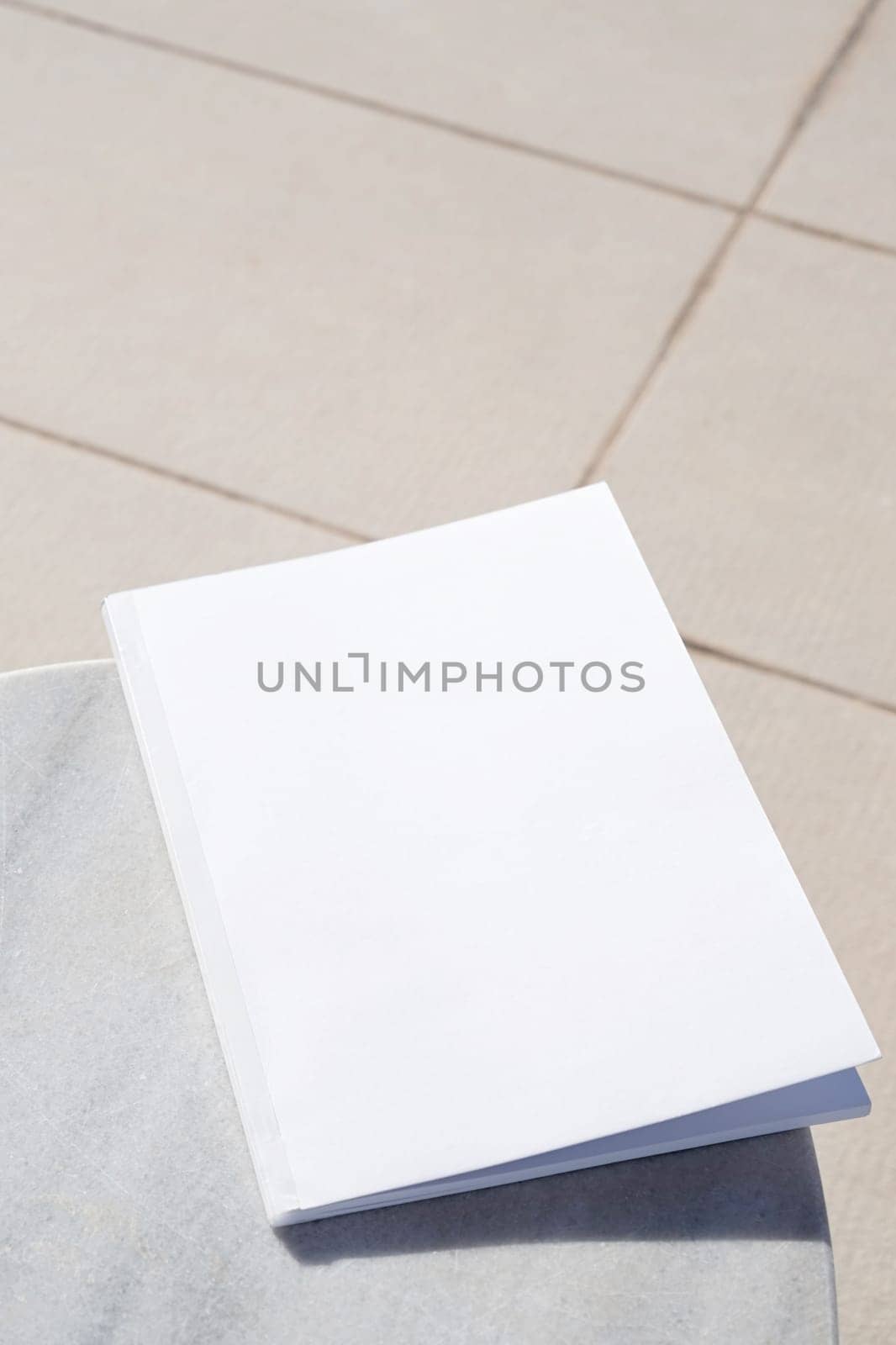blank magazine for mockup design on marble table by the swimming pool by Desperada