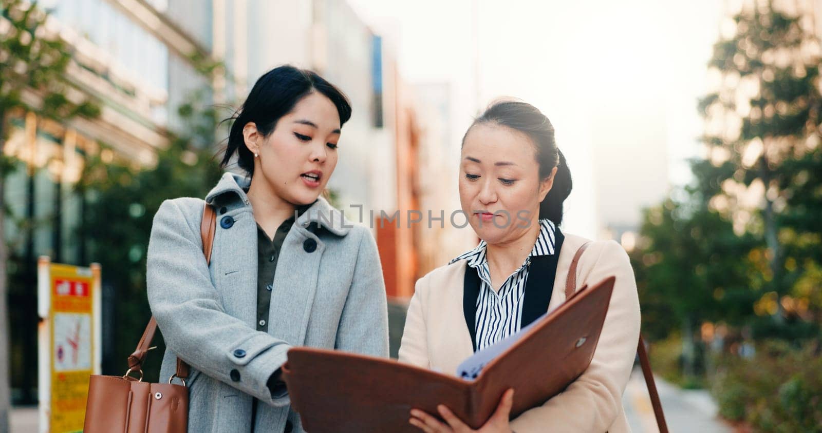 Businesswomen, japan and discussion by sidewalk in city, walking and collaboration on working in corporate career. Manager, employee or communication in professional job in kyoto or project feedback.