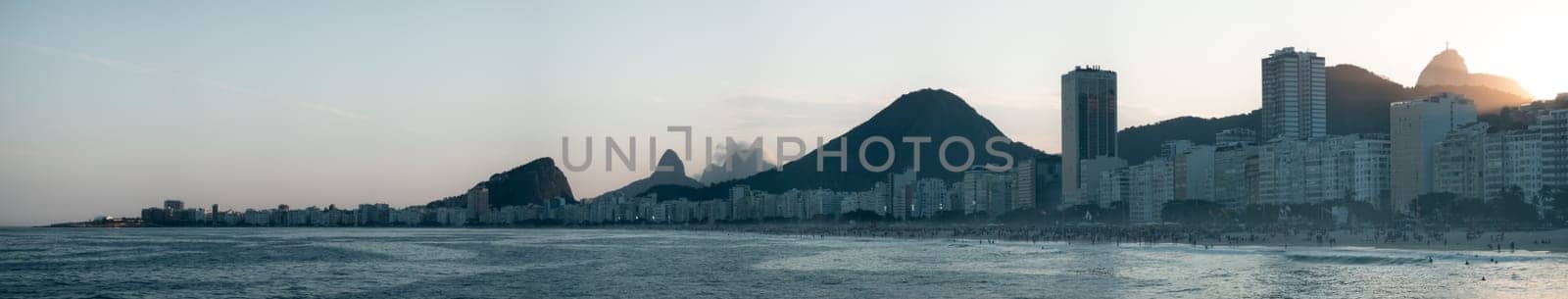 Tranquil view of Rio de Janeiro's skyline featuring Sugarloaf Mountain at sunset.