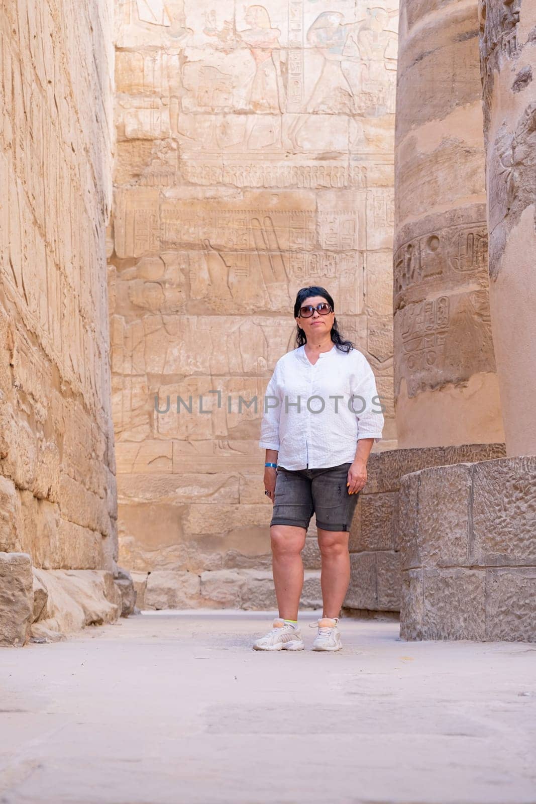 Woman traveler explores the ruins of the ancient Karnak temple in the city of Luxor in Egypt. by Desperada