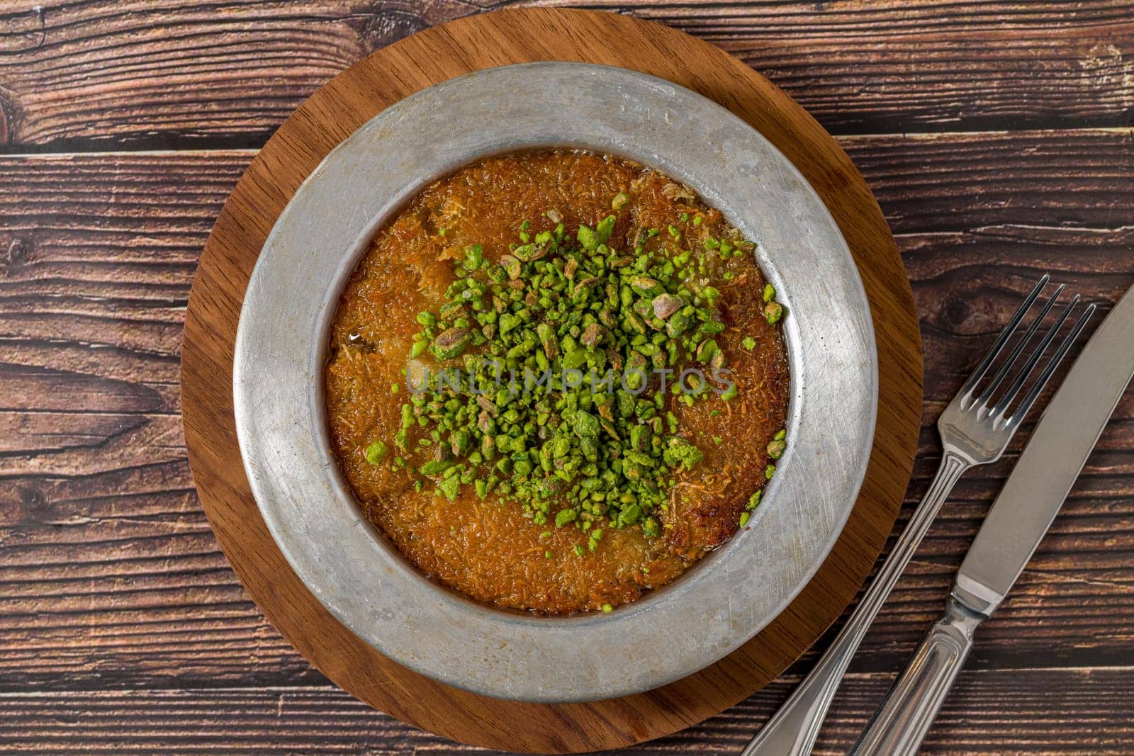 Traditional Turkish dessert pistachio kunefe on wooden table