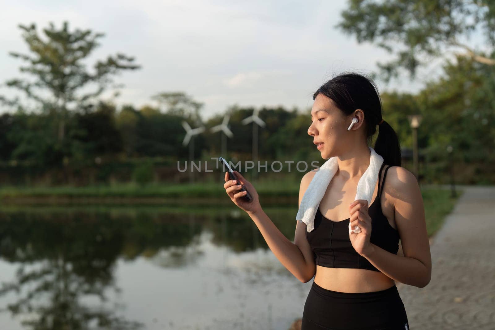 Women use mobile phone and wear headphones during exercise. Workout concept by itchaznong