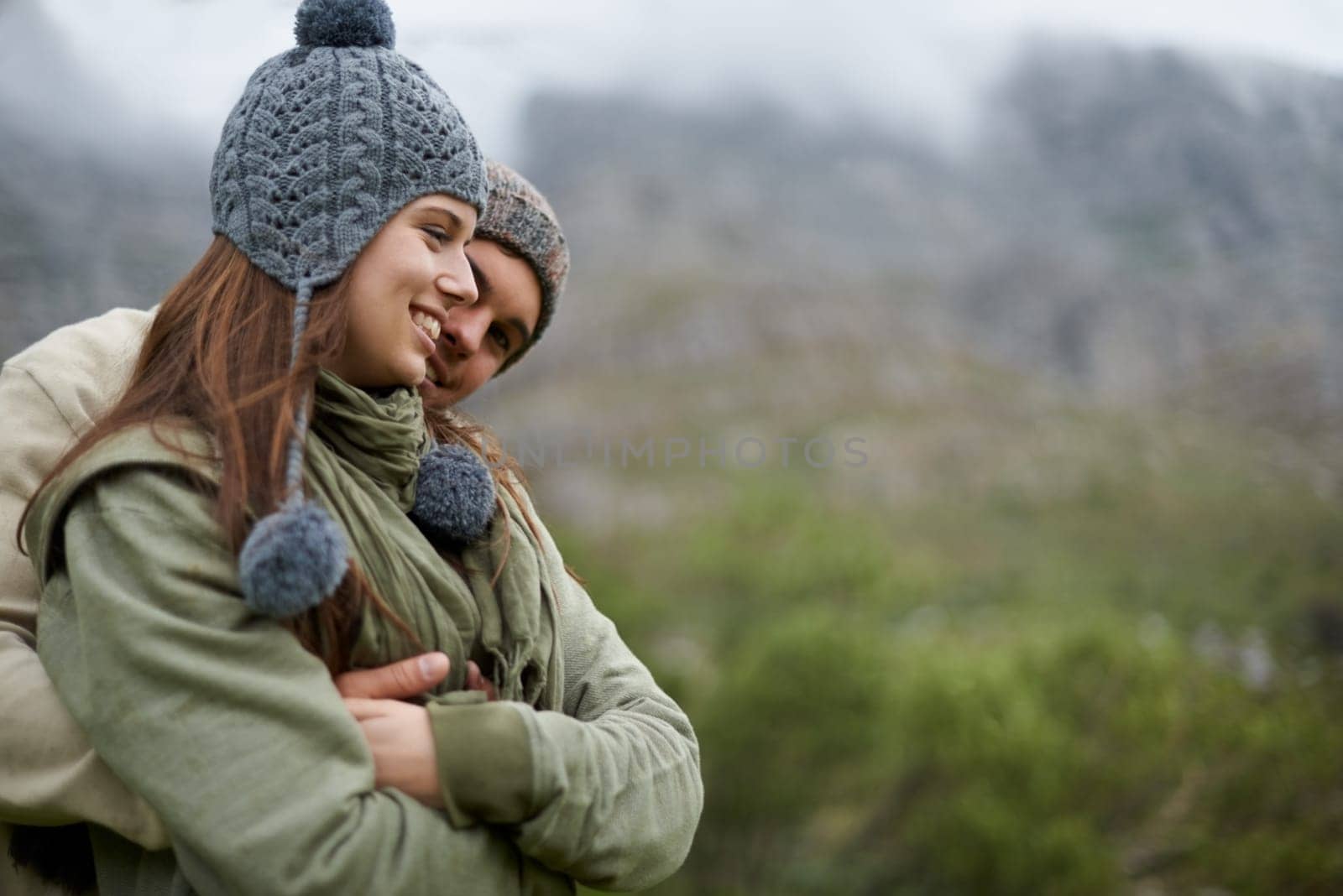 Couple, hug and smile on hiking vacation in outdoors, love and bonding in relationship for connection. People, embrace and travel for exploring adventure, romance and security in marriage on mountain.