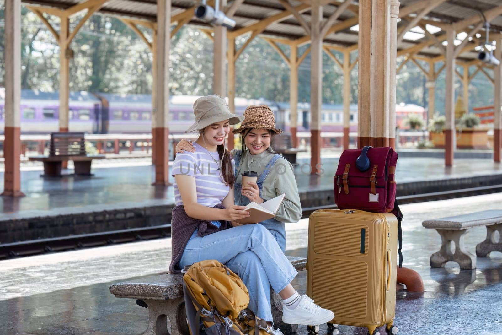 Woman traveler with backpack looking at planning vacation on holiday relaxation at the train station by itchaznong