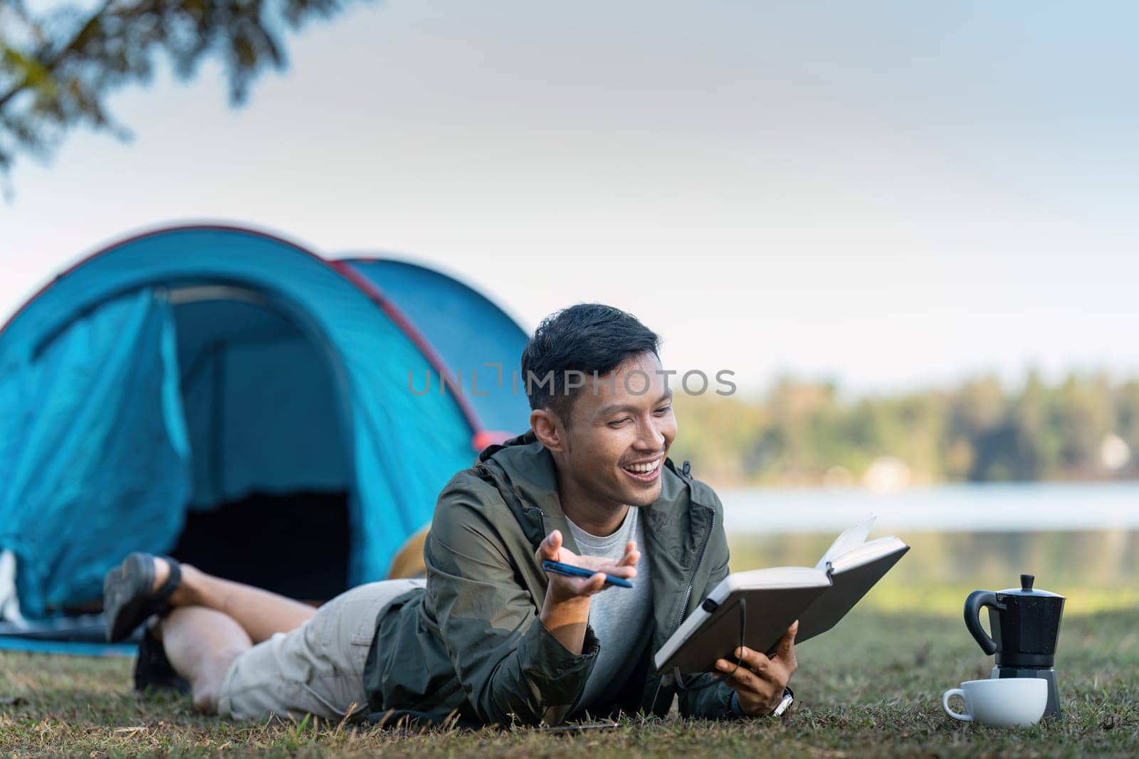 Man read book while traveler with camping. Concept of modern people lifestyle in working by nateemee