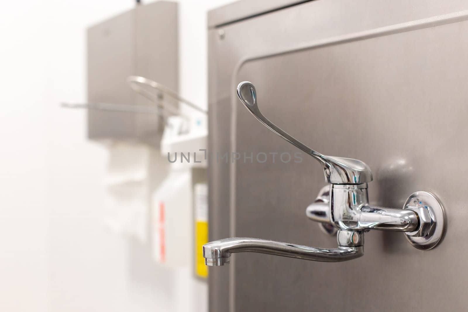 Close-up of a chrome Industrial-style public water tap in the surgery department at the hospital by Zakharova