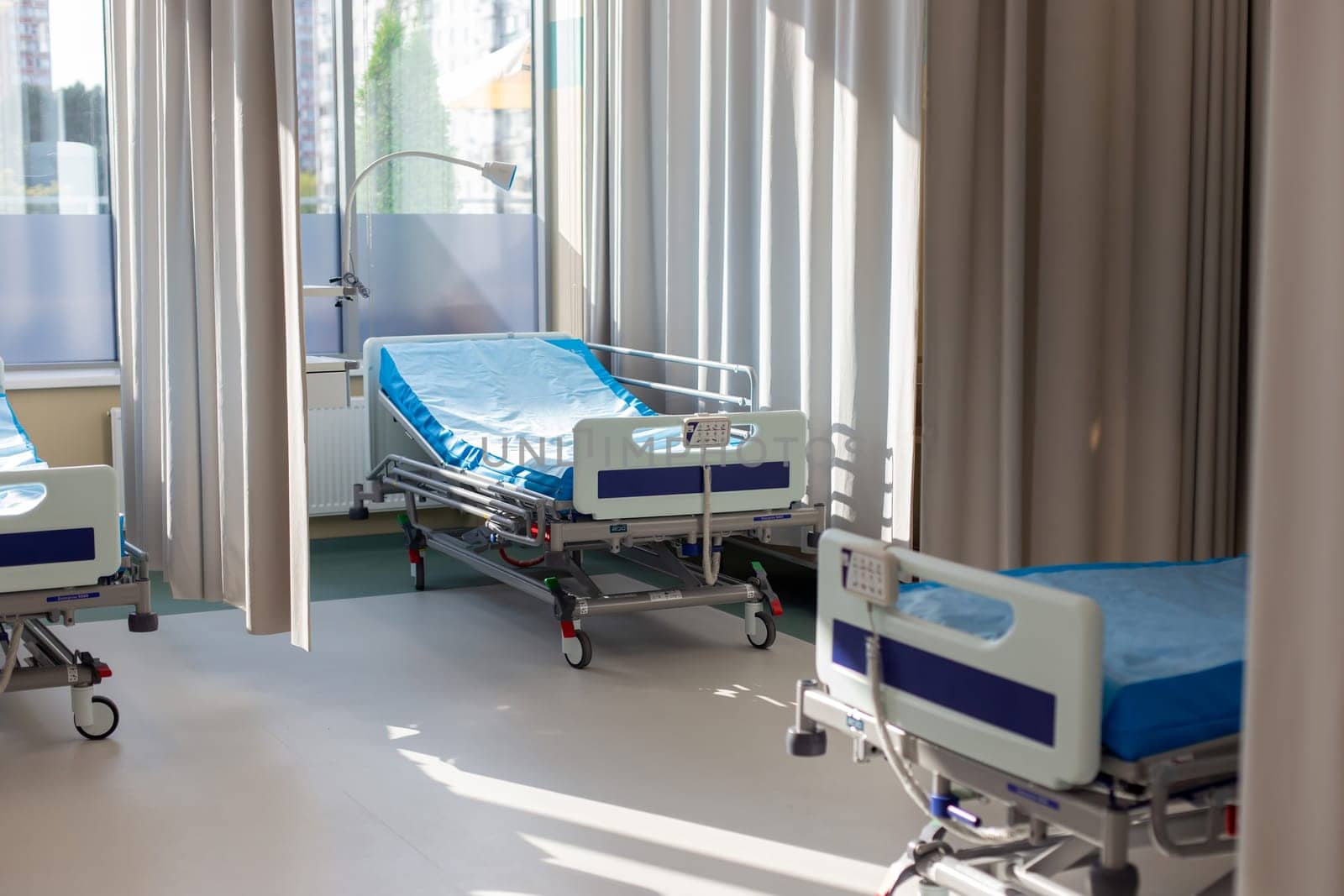 Moscow, Moscow region, Russia - 03.09.2023:Modern hospital room with unoccupied beds and sunlit curtains