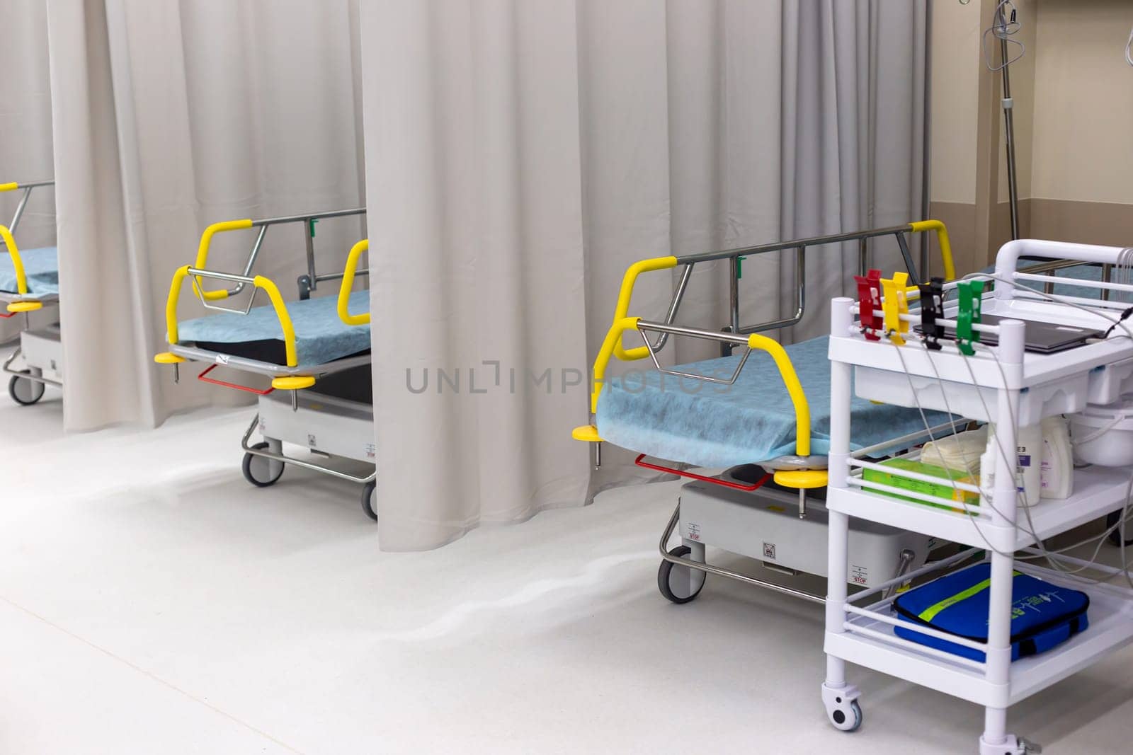 Moscow, Moscow region, Russia - 03.09.2023:Empty hospital ward showing multiple beds with safety rails and a medical cart with supplies, ready for patients