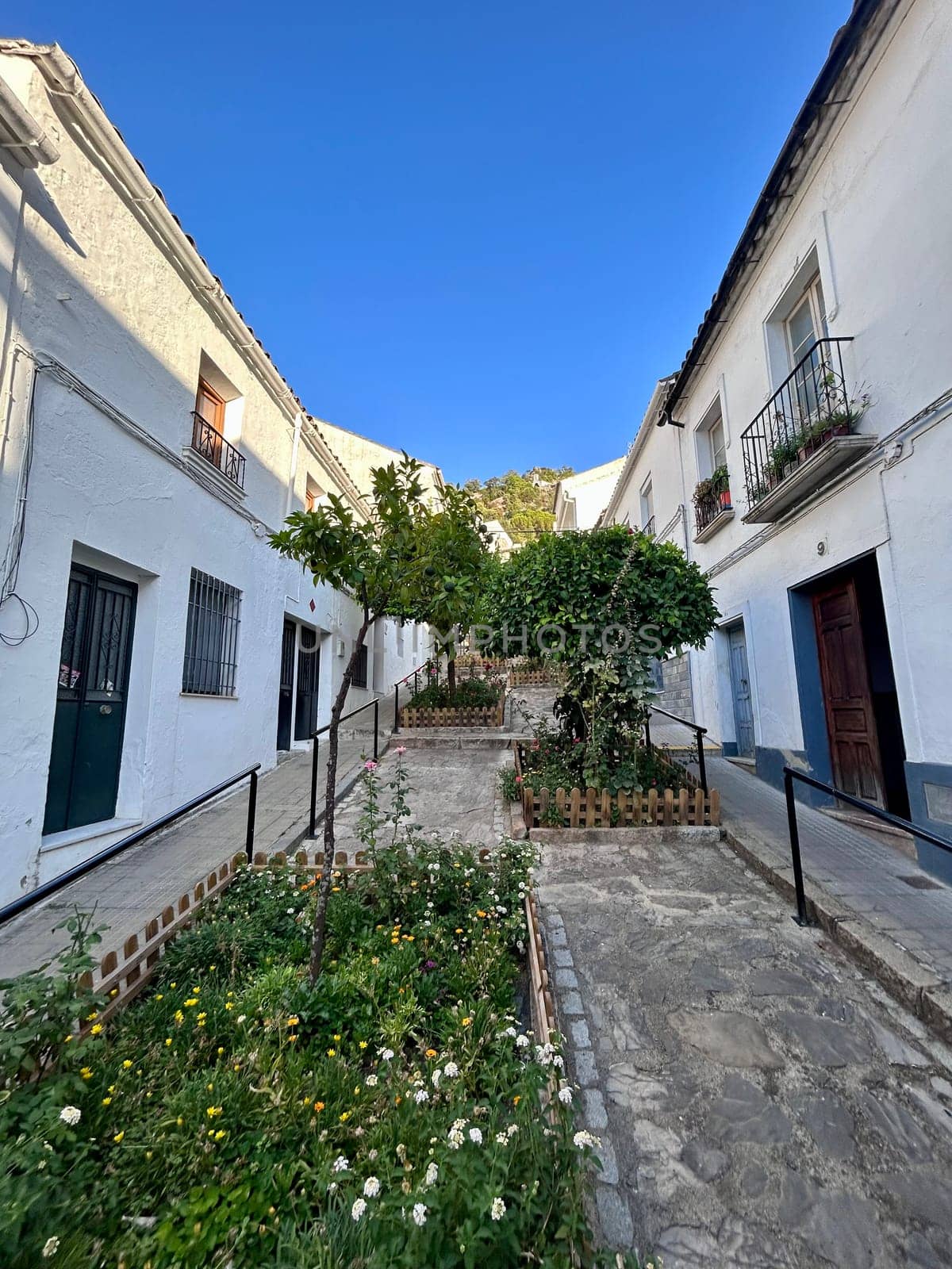 A narrow alley way with white buildings in the background. High quality photo