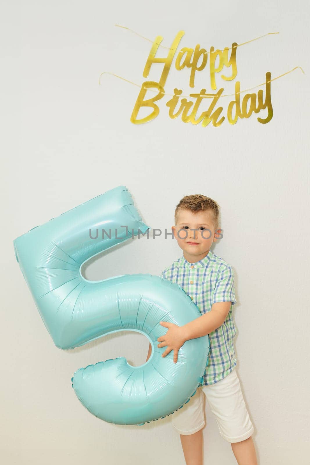 Boy with the number five for his birthday at home