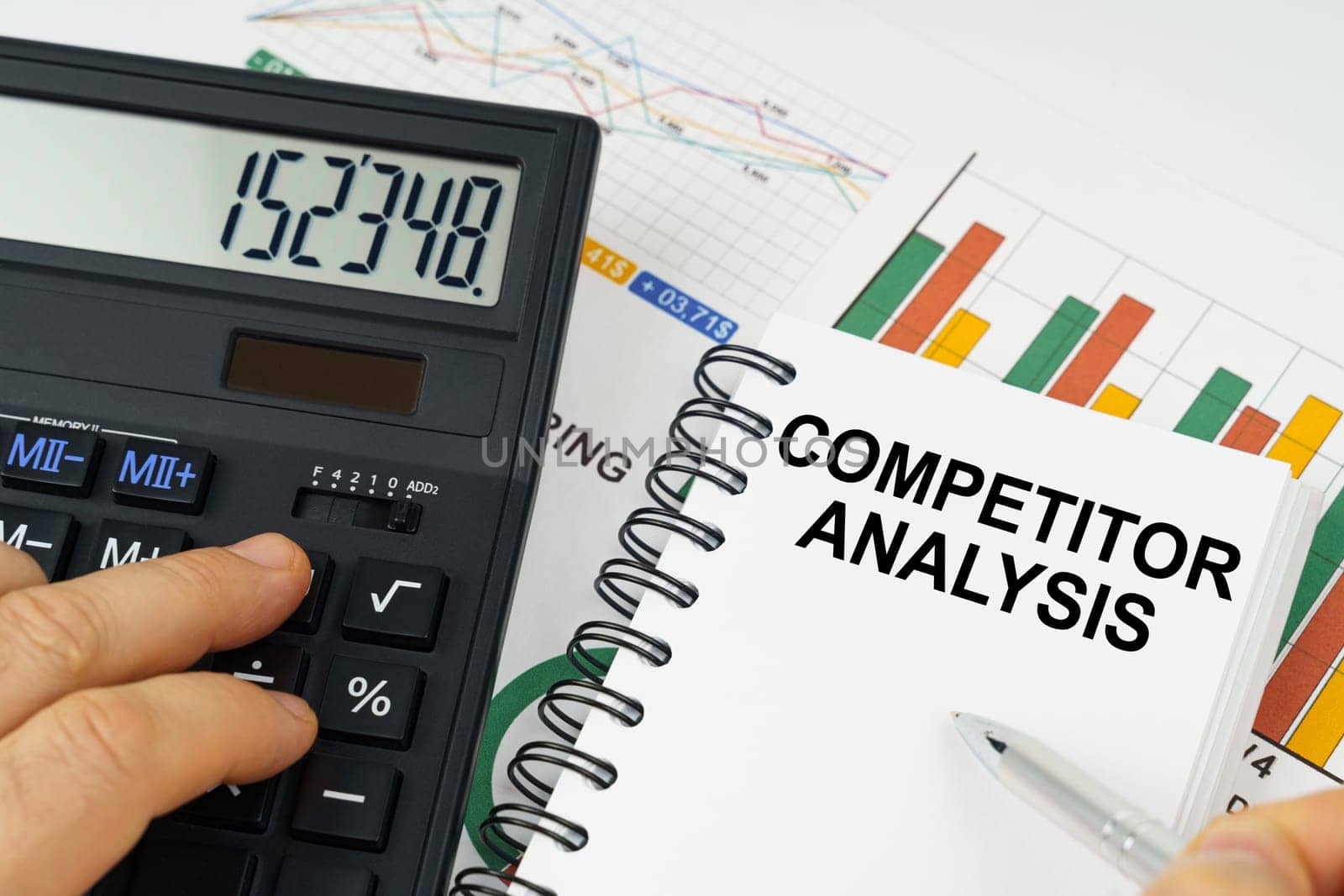 On the table there is a calculator, reports with graphs and a notepad with the inscription - Competitor Analysis by Sd28DimoN_1976