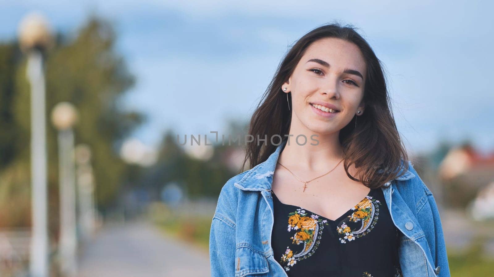 Portrait of a cheerful girl in a denim jacket at night in the city. by DovidPro