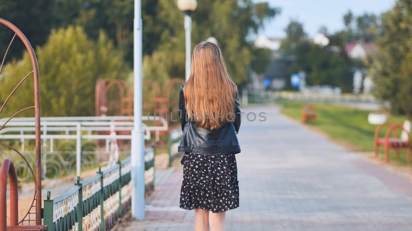 A lonely girl walks along the city's promenade. by DovidPro
