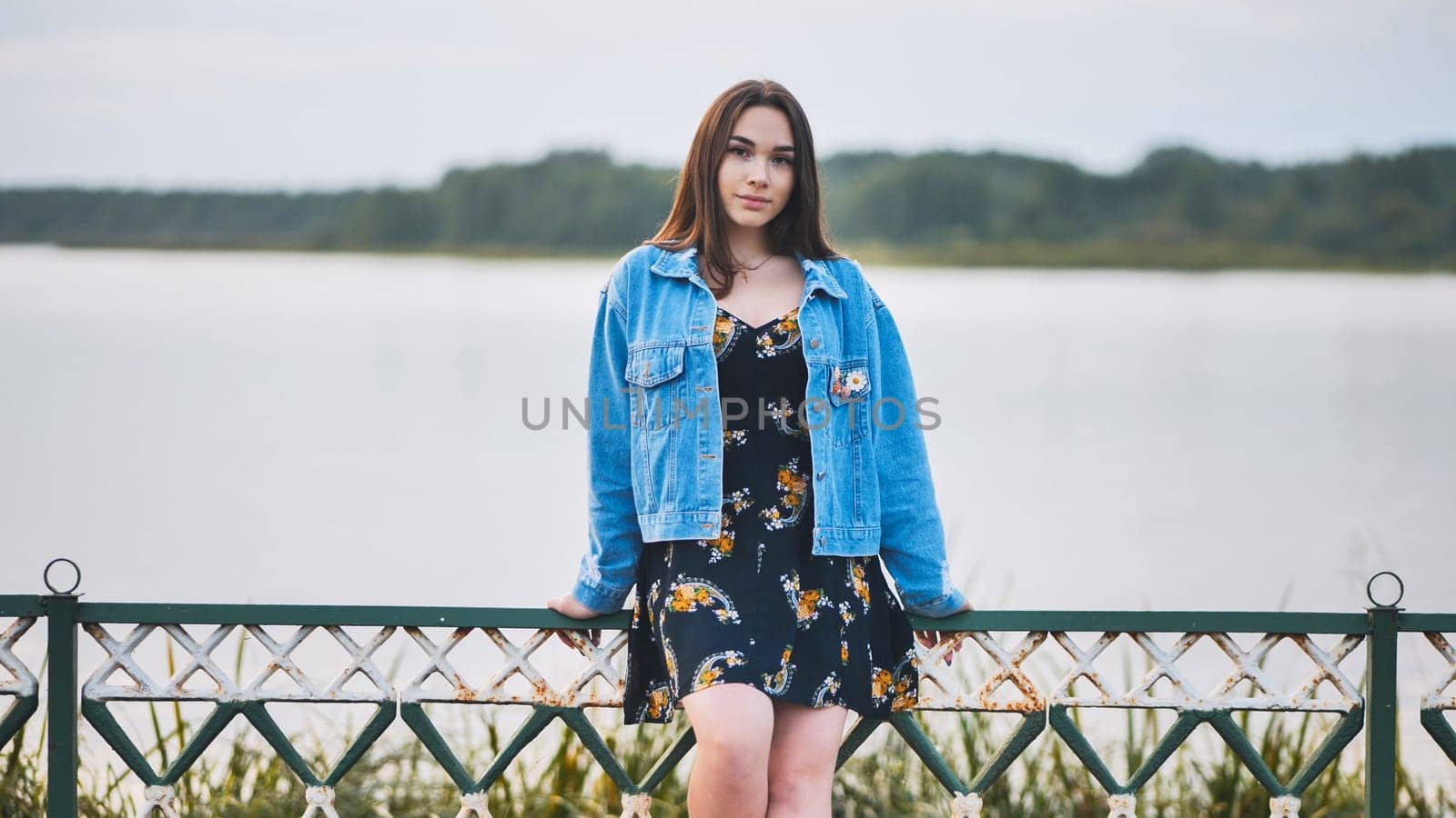 Portrait of a lonely girl by a lake