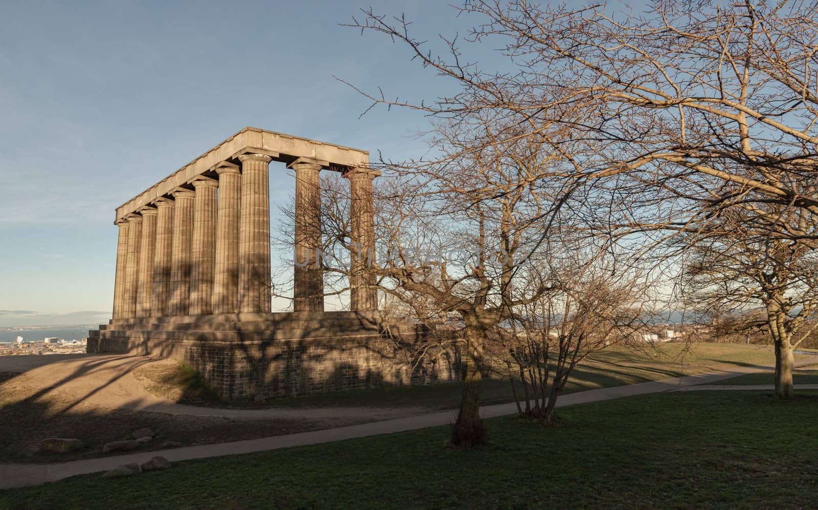 Edinburgh, Scotland - Jan 18, 2024 - A view of the National Monument of Scotland with a bright blue sky in the background situated on Calton Hill at Edinburgh city. Scotland, Space for text, Selective focus.