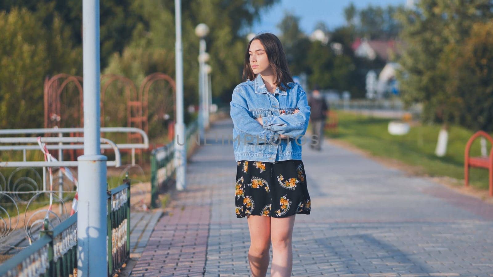 A lonely girl walks along the city's promenade