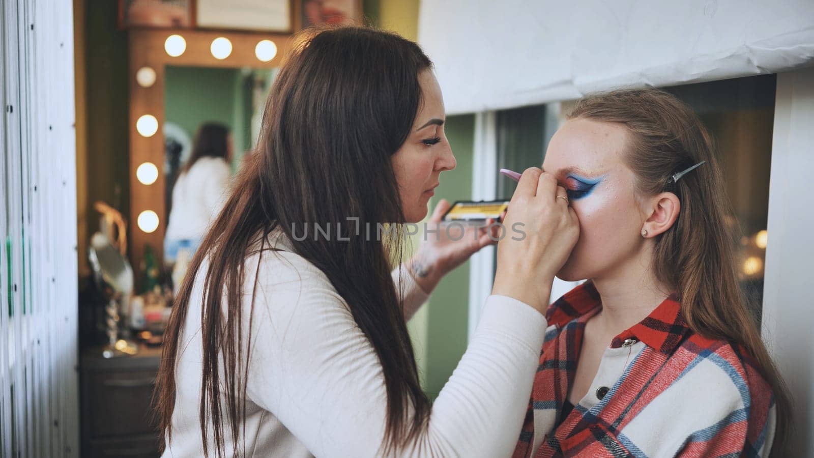 The makeup artist paints the model's eyes