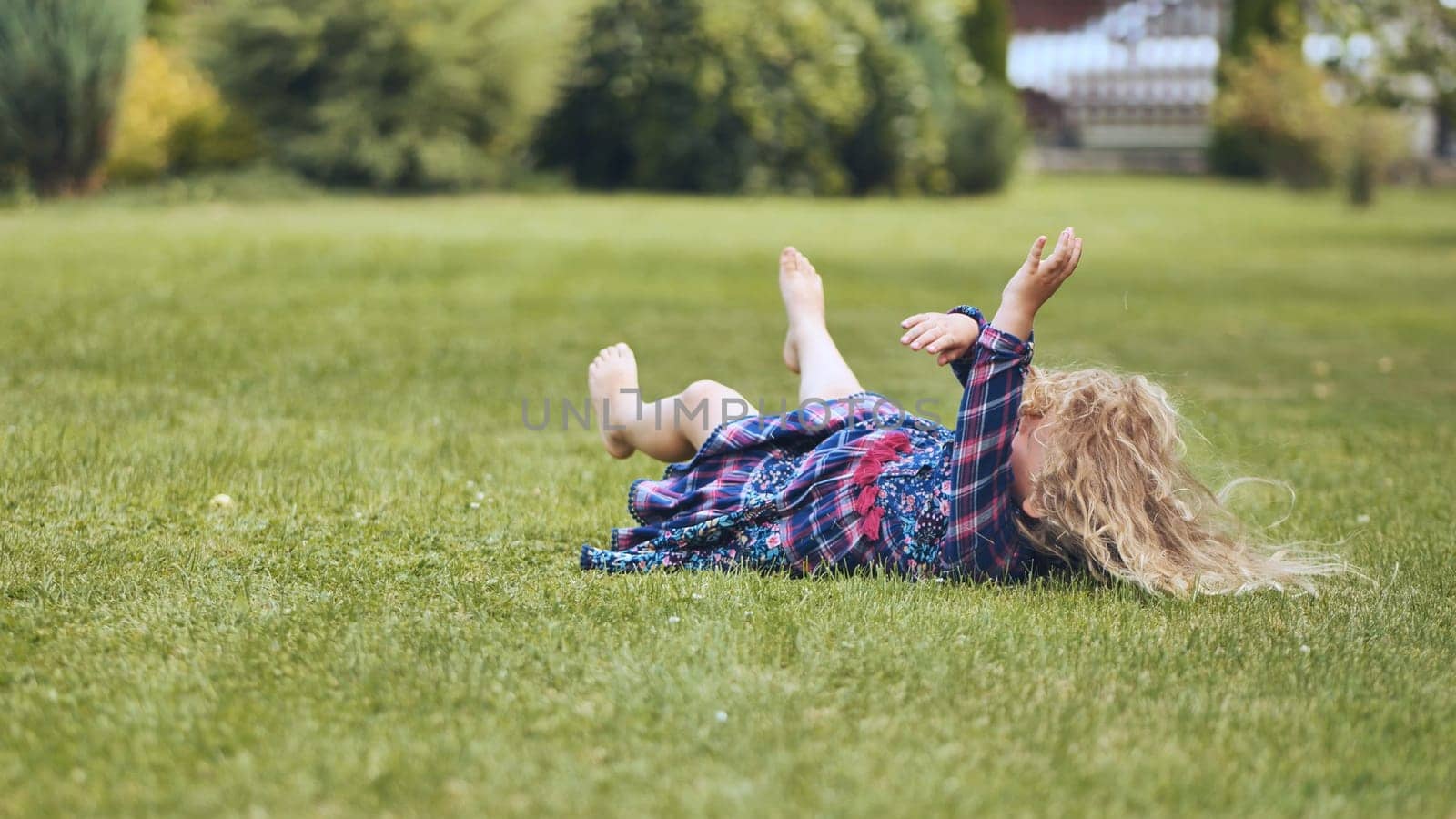 A girl is lying on the grass in the garden