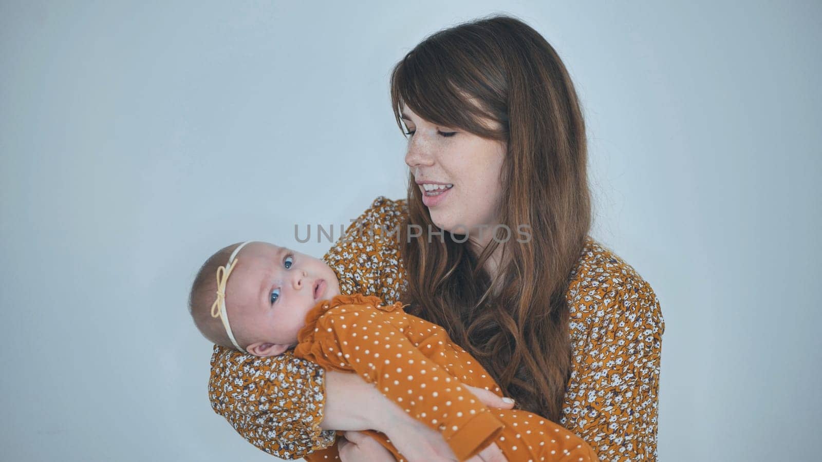 A loving mother sings for her child against a gray background. by DovidPro