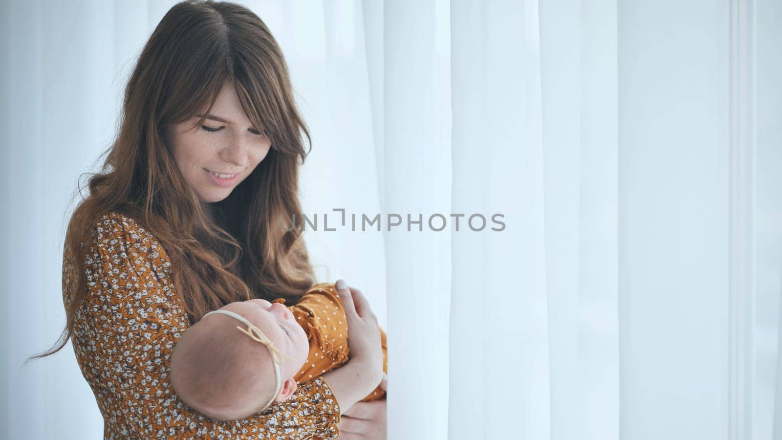 A loving mother and child at the window with curtains