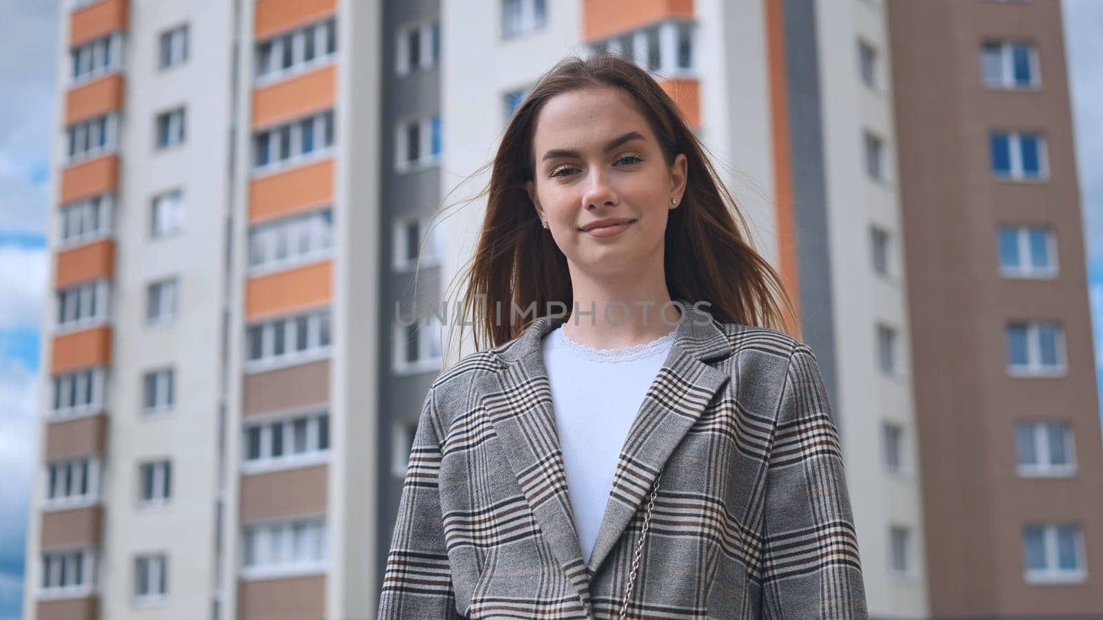 Portrait of a girl in front of a high-rise apartment building