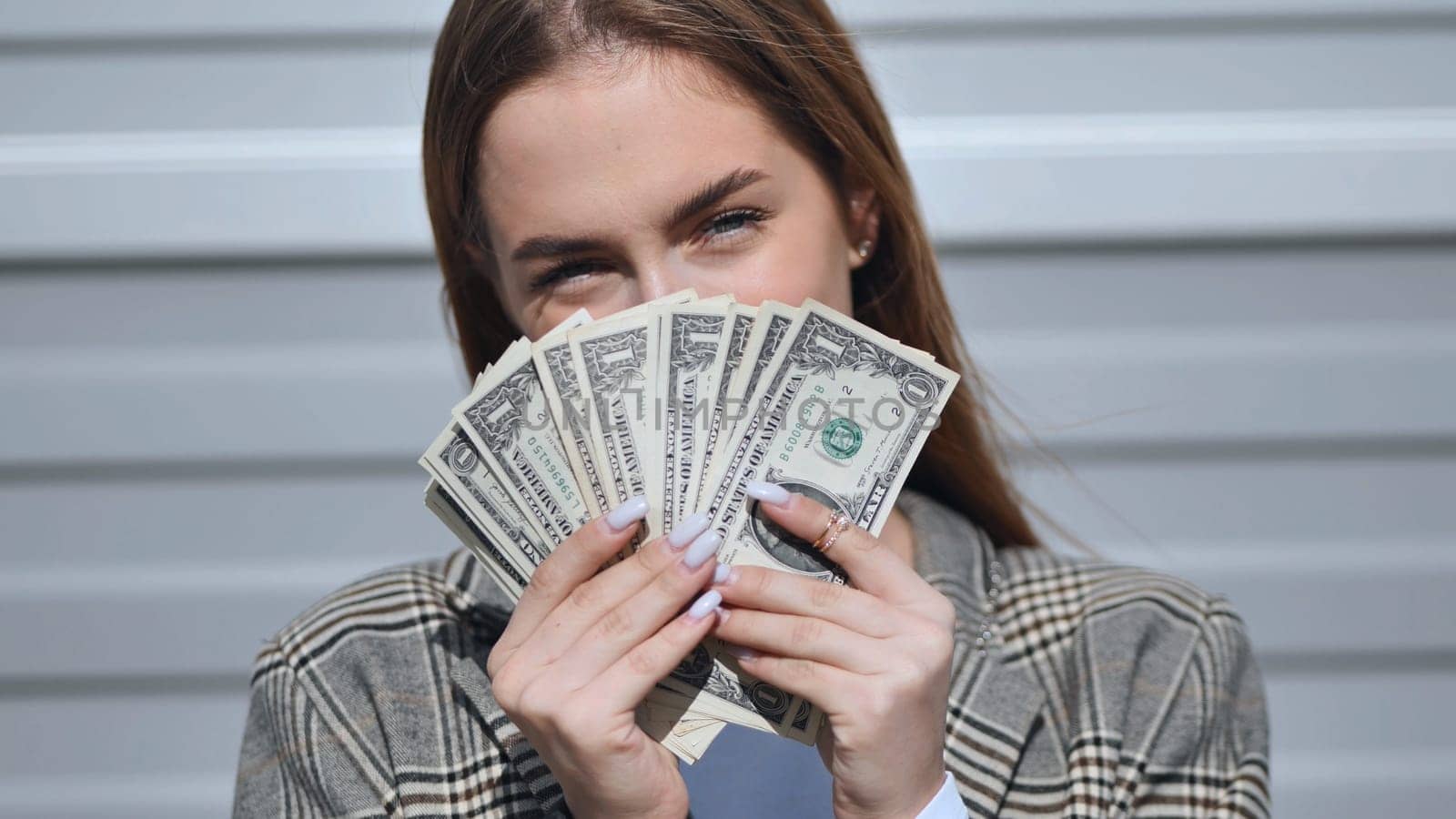 Young girl showing dollars in the street