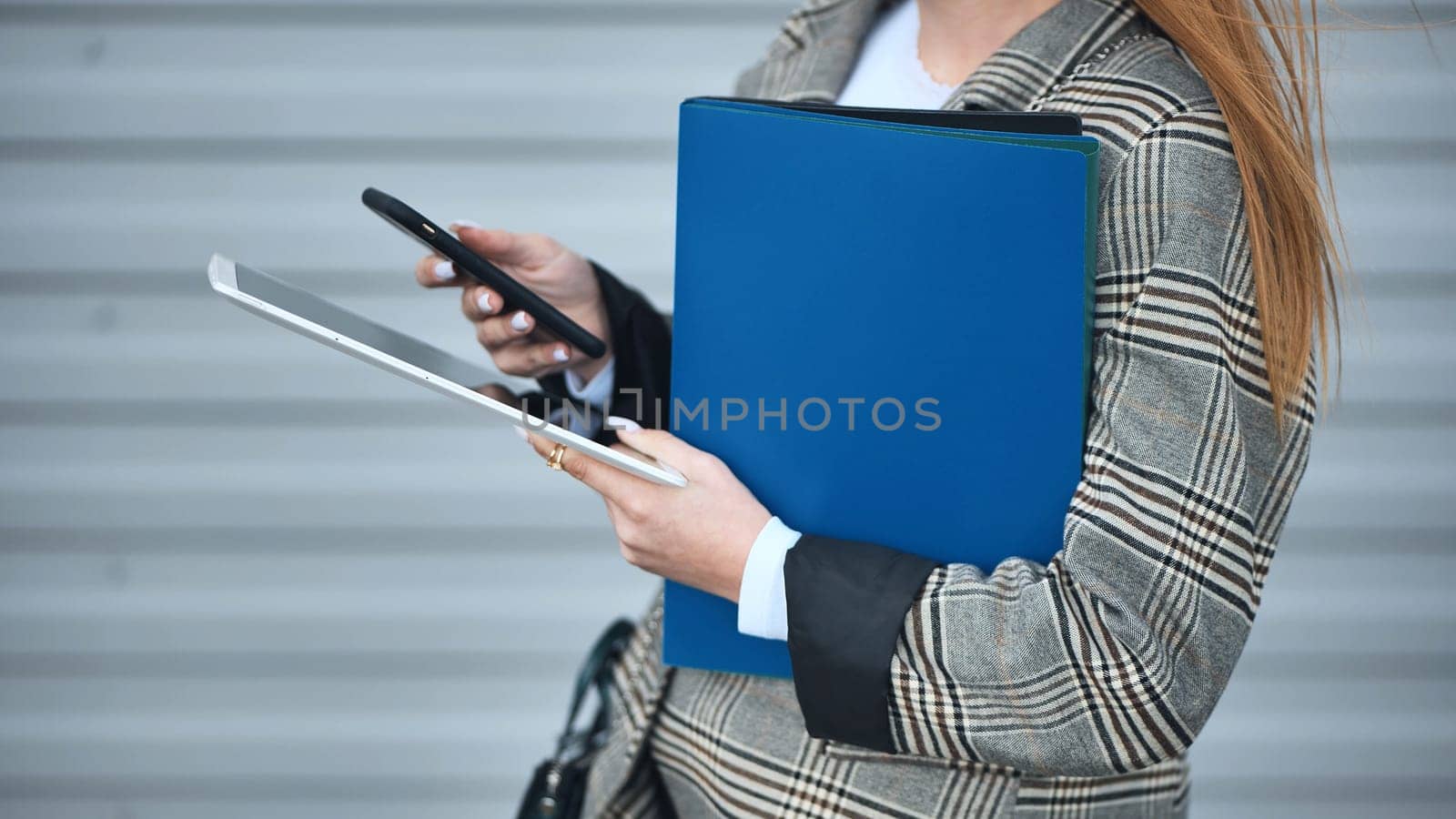 Business woman works with a tablet and a phone. by DovidPro