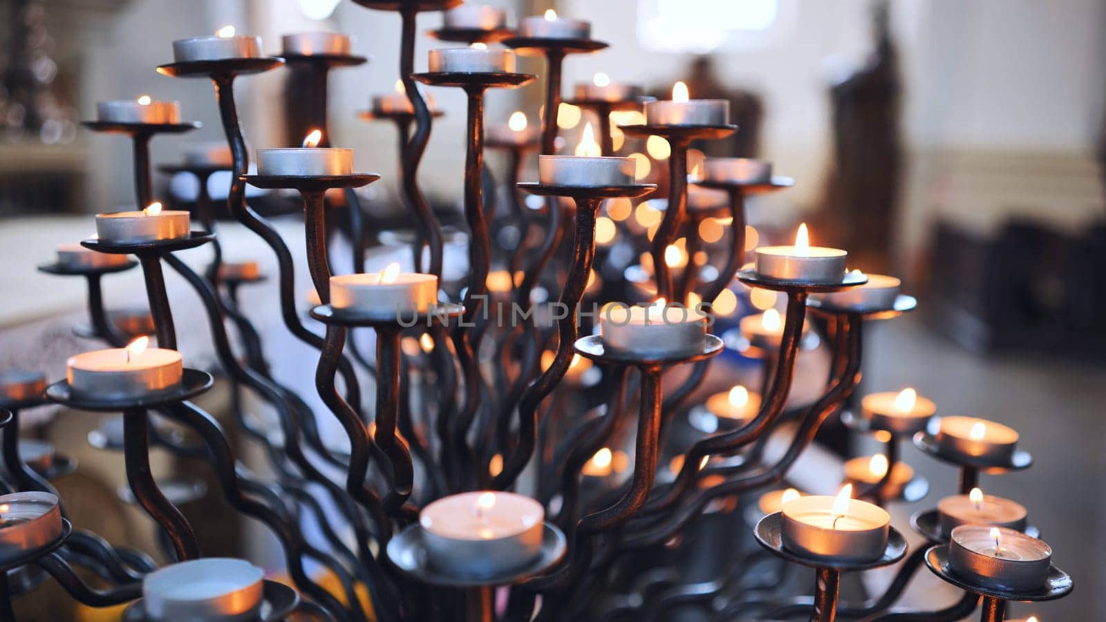 Candlestick holder with burning candles in a Catholic church