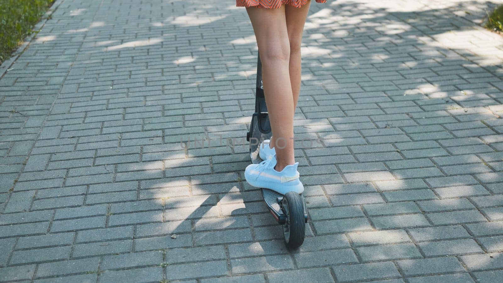 A girl rolls around on city tiles in the park