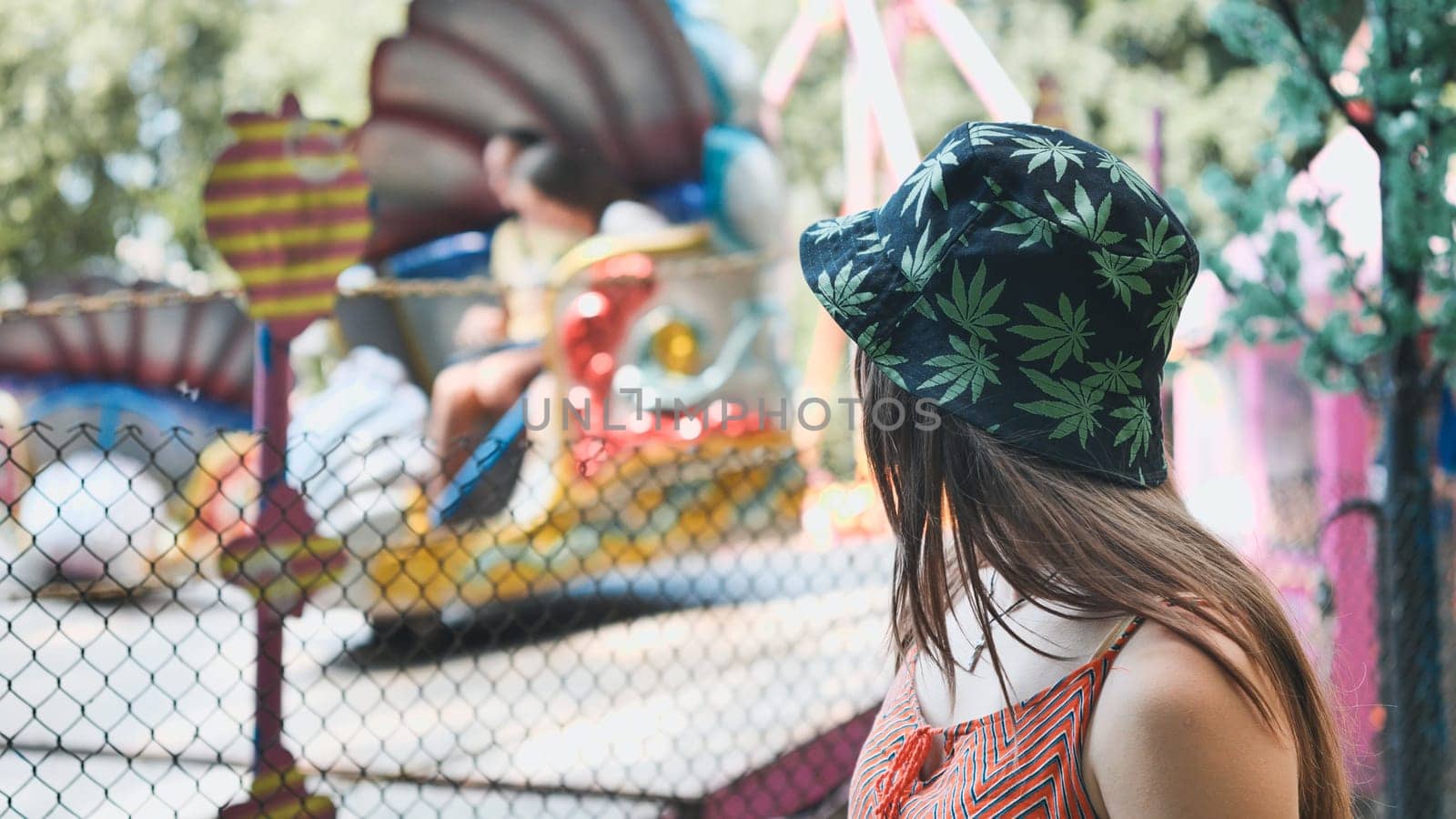 A girl looks at a working ride in a children's park