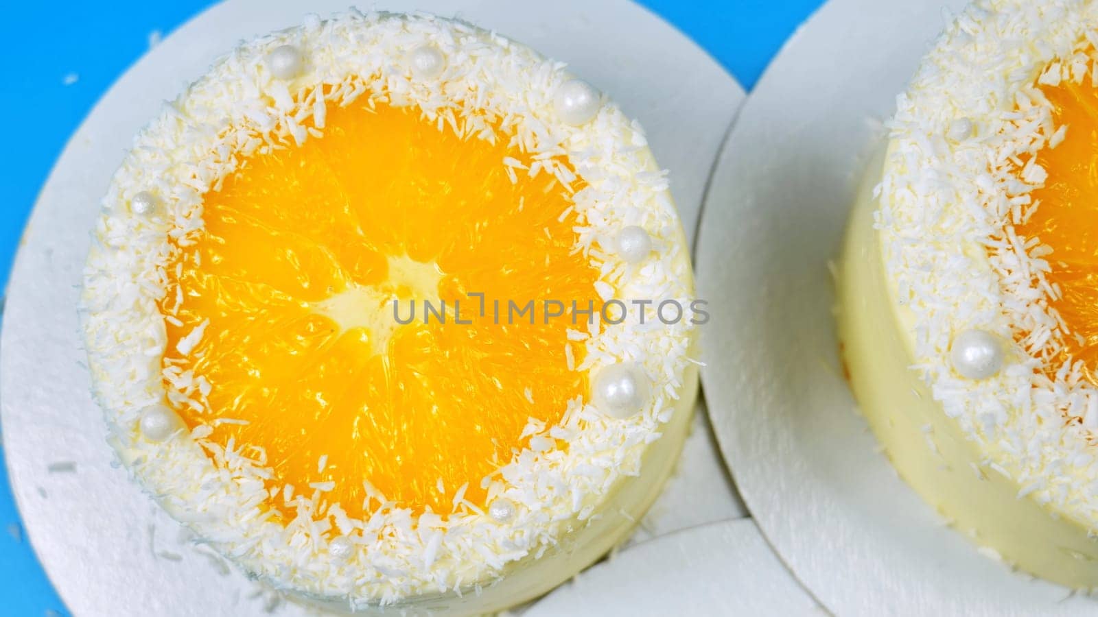 Small cakes with orange and coconut on a blue background. by DovidPro
