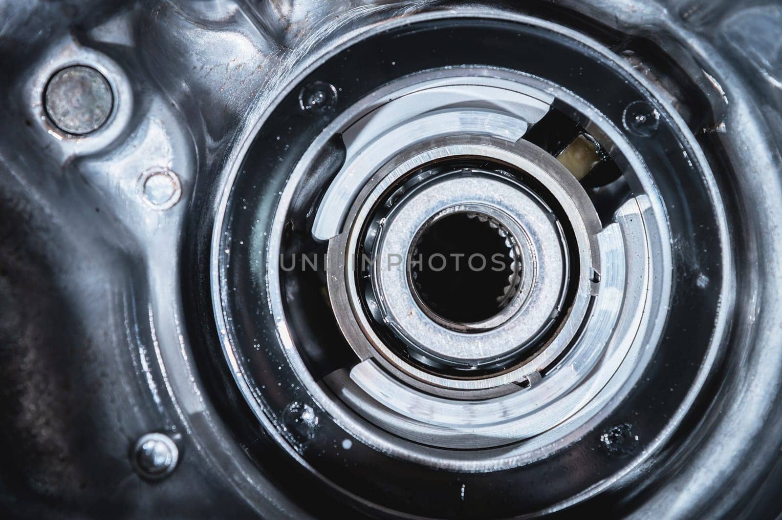 A close-up of a pack of clutches on a shaft with a gear from an automatic transfer case of a four-wheel drive car. Toned image. by yanik88