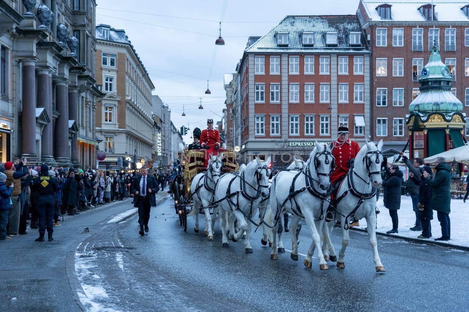 Copenhagen, Denmark - January 04, 2024: Queen Margrethe in her 24-carat golden coach is escorted by the Guard Hussar Regiment on the way from Christiansborg Palace to Amalienborg Palacce