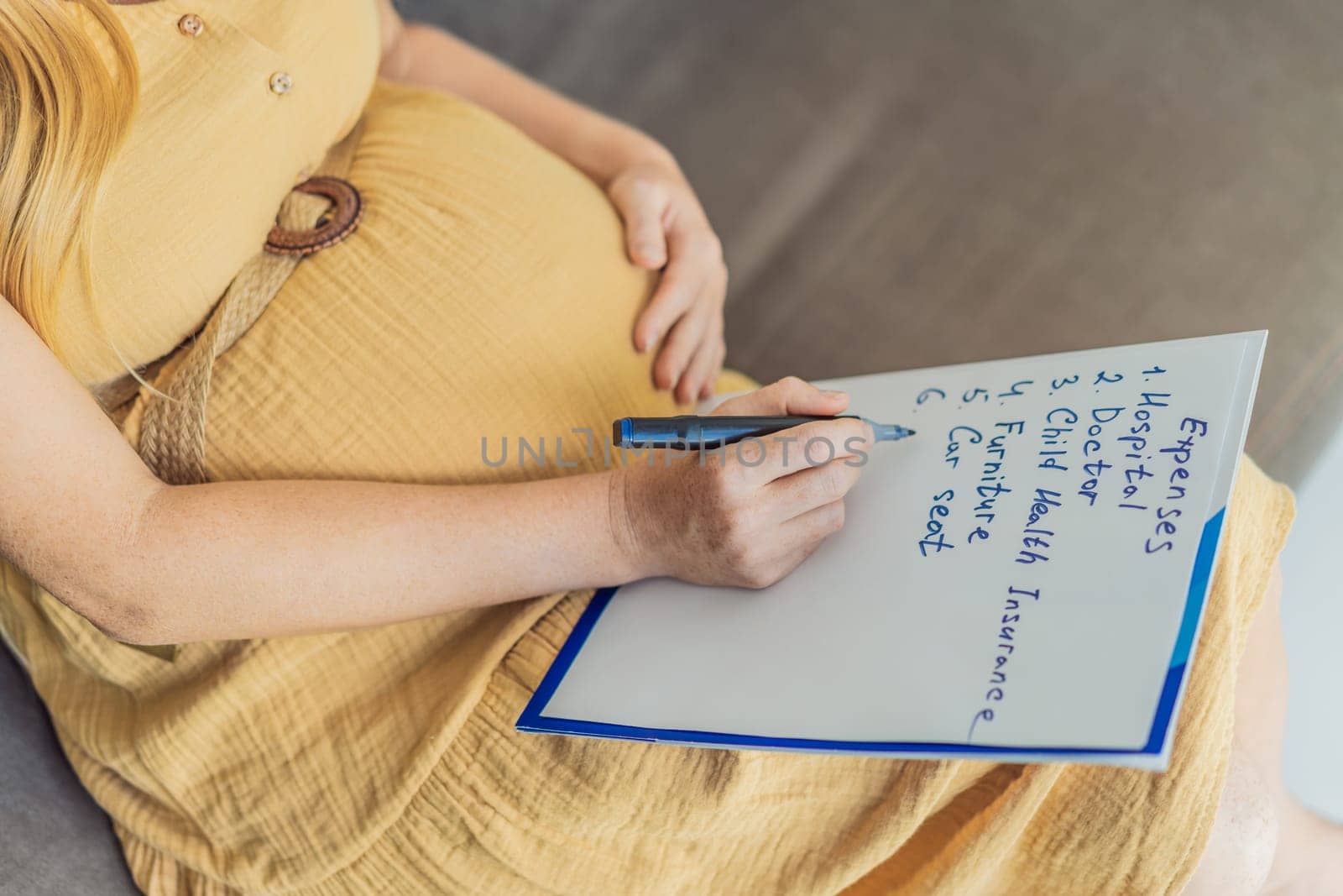Expectant woman diligently compiles a list of childbirth costs, planning and organizing financial considerations for the upcoming delivery by galitskaya