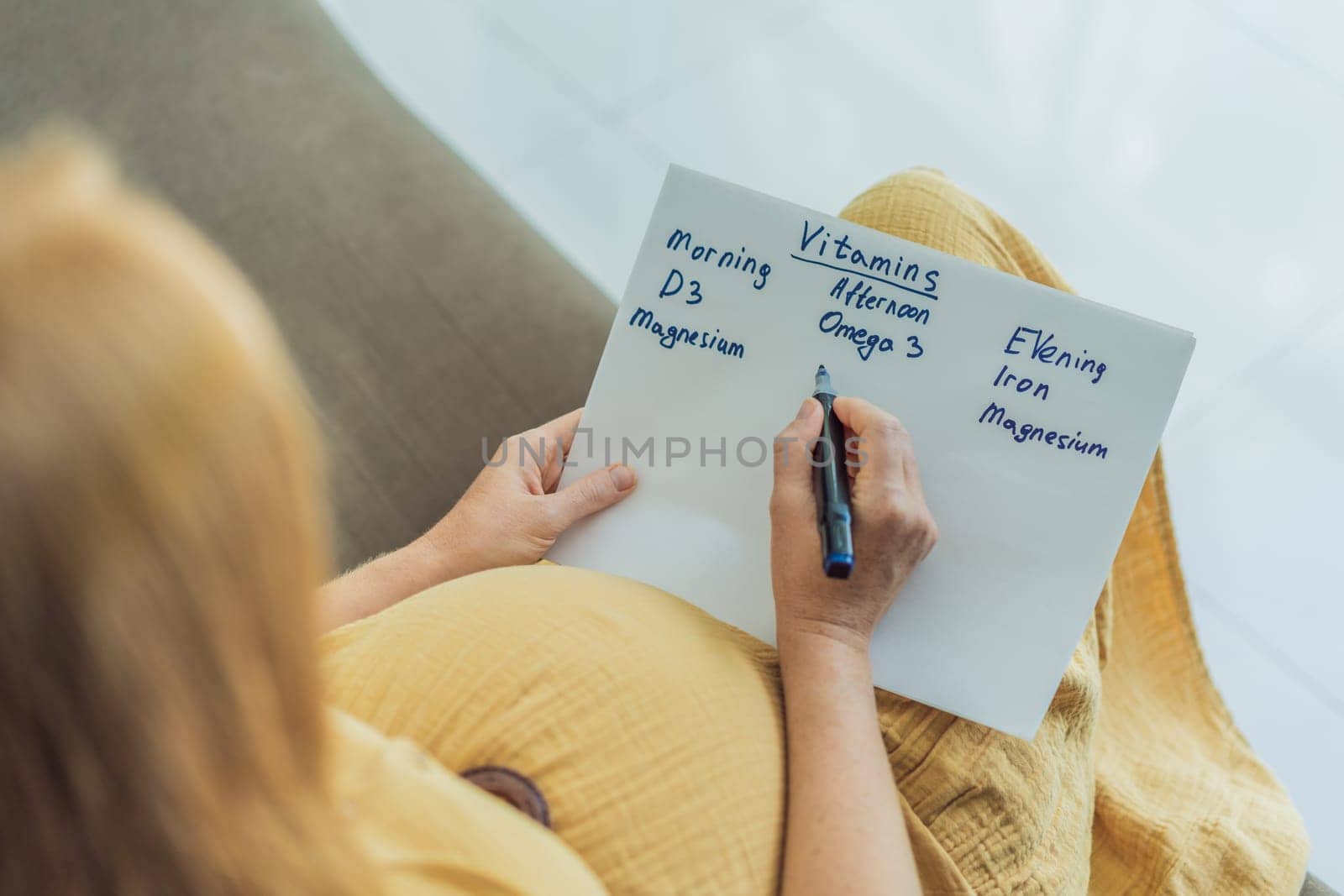 Expectant woman diligently compiles a list of doctor-prescribed vitamins for a healthy pregnancy, ensuring optimal care and well-being by galitskaya