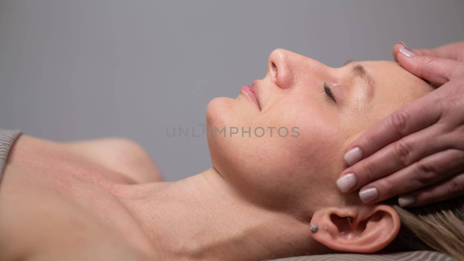 Caucasian woman undergoing head and face massage procedure