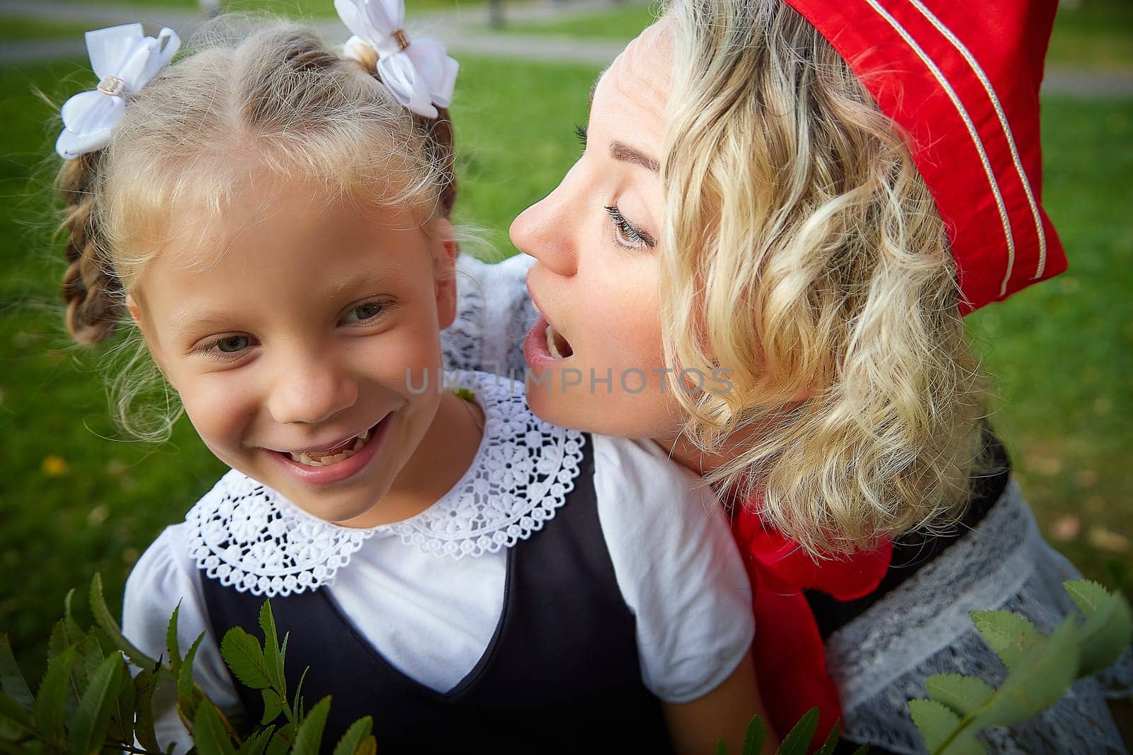 Young and adult schoolgirl on September 1. Generations of schoolchildren of USSR and modern Russia. Female pioneer in red tie and October girl in modern uniform. Mother and daughter having fun by keleny