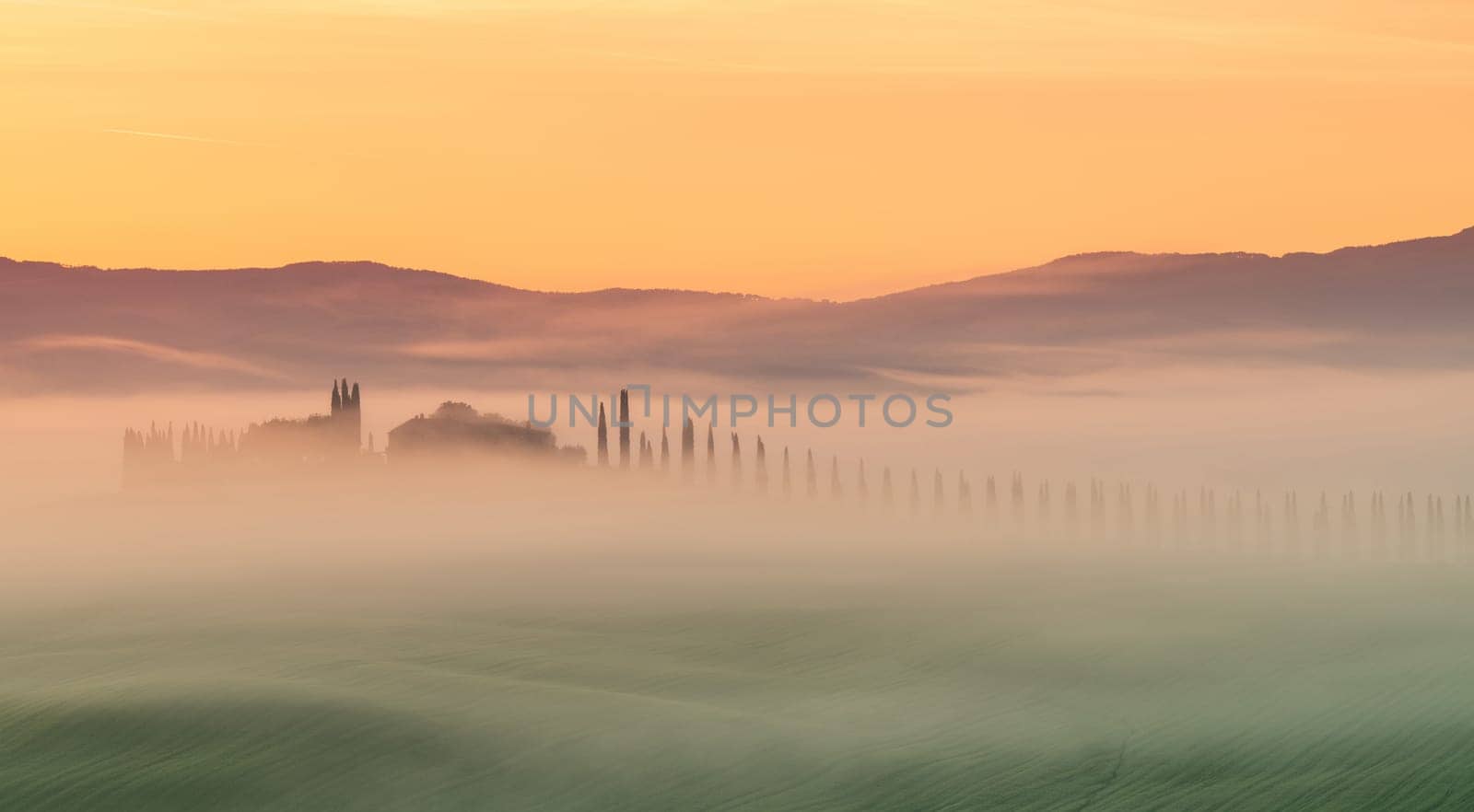 Path to hill house through cypress trees and sunrise view of stunning rural landscape of Tuscany, Italy