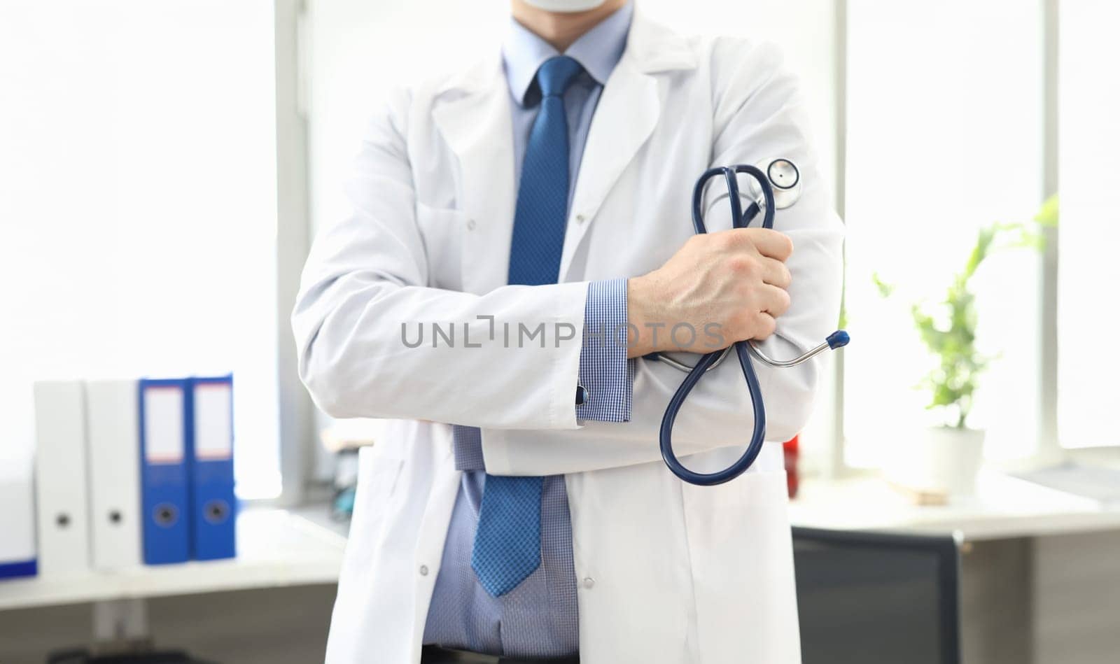 Doctor standing in office with stethoscope in his hand. Platform for online consultation with doctors. Family doctor appointment online. Pandemic disease prevention. Elucidation medical history