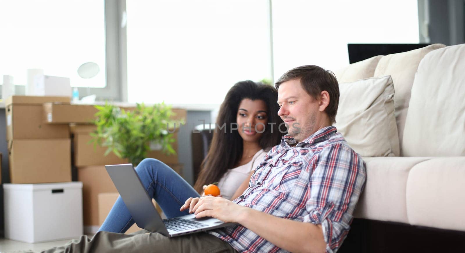 Guy with girl sitting with laptop floor apartment by kuprevich