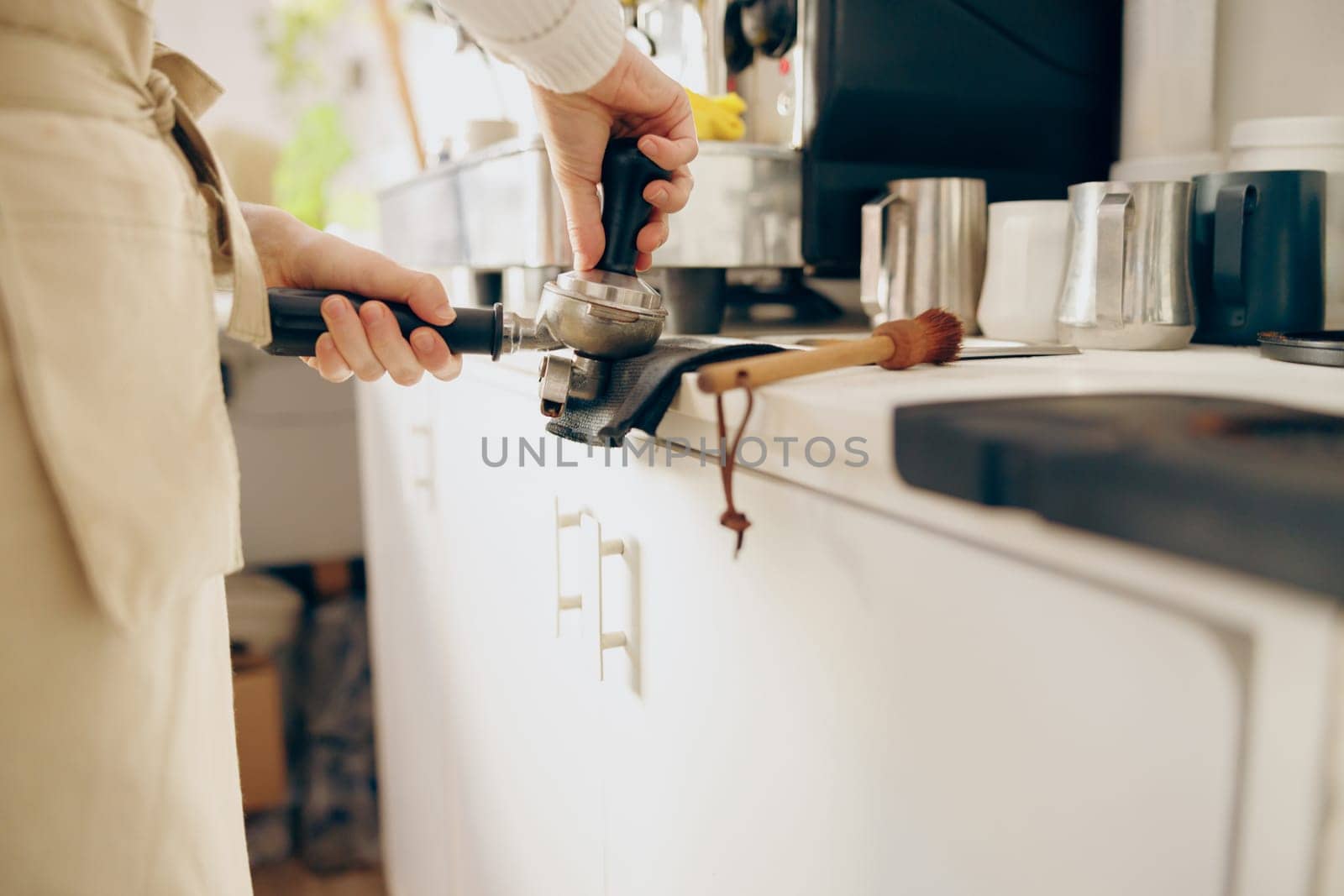 Close-up of barista making coffee with manual presses using tamper at the coffee shop by Yaroslav_astakhov