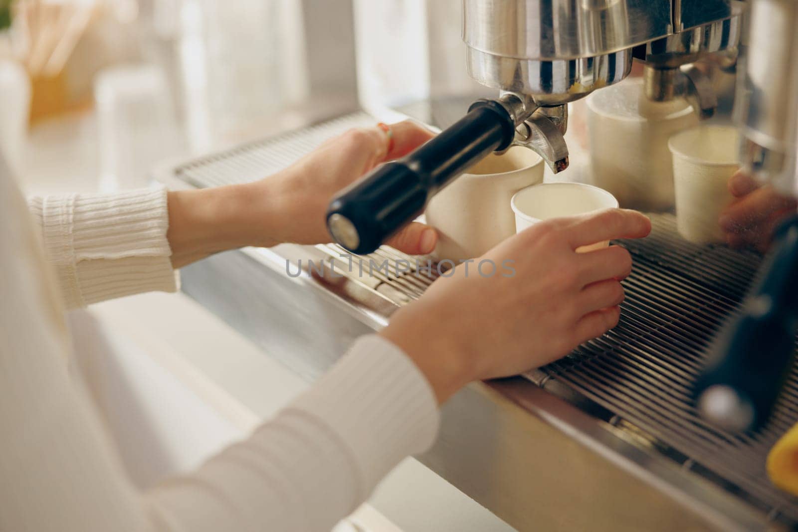 Barista use coffee machine for filling a two cups with espresso in professional coffee shop