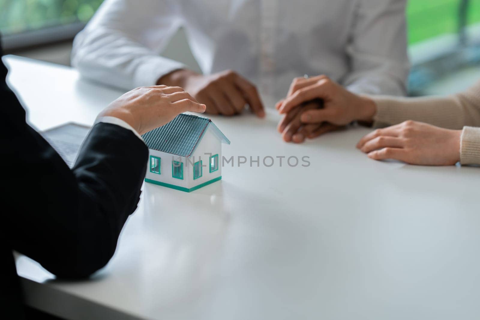 Young couple is listening to home purchase agreement with bank by taking out joint loan.