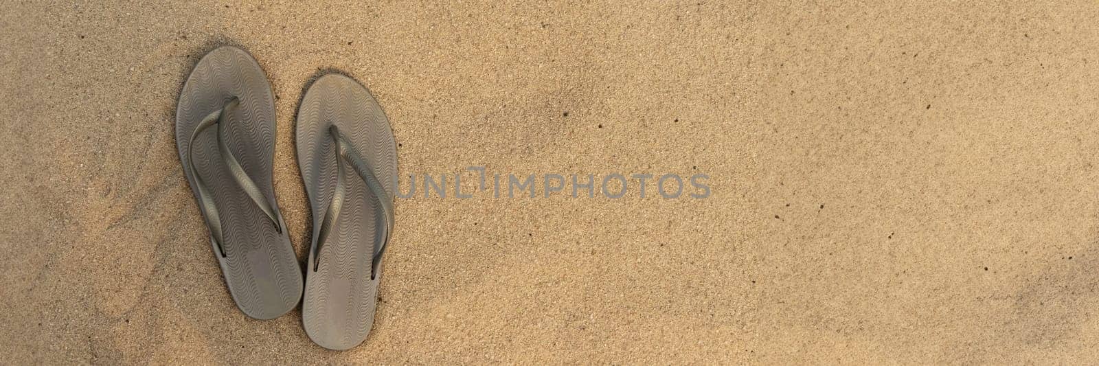 banner of light sandal or flip flops on the beach. golden sand. place for your text. top view. concept of summer and vacation at sea by Leoschka